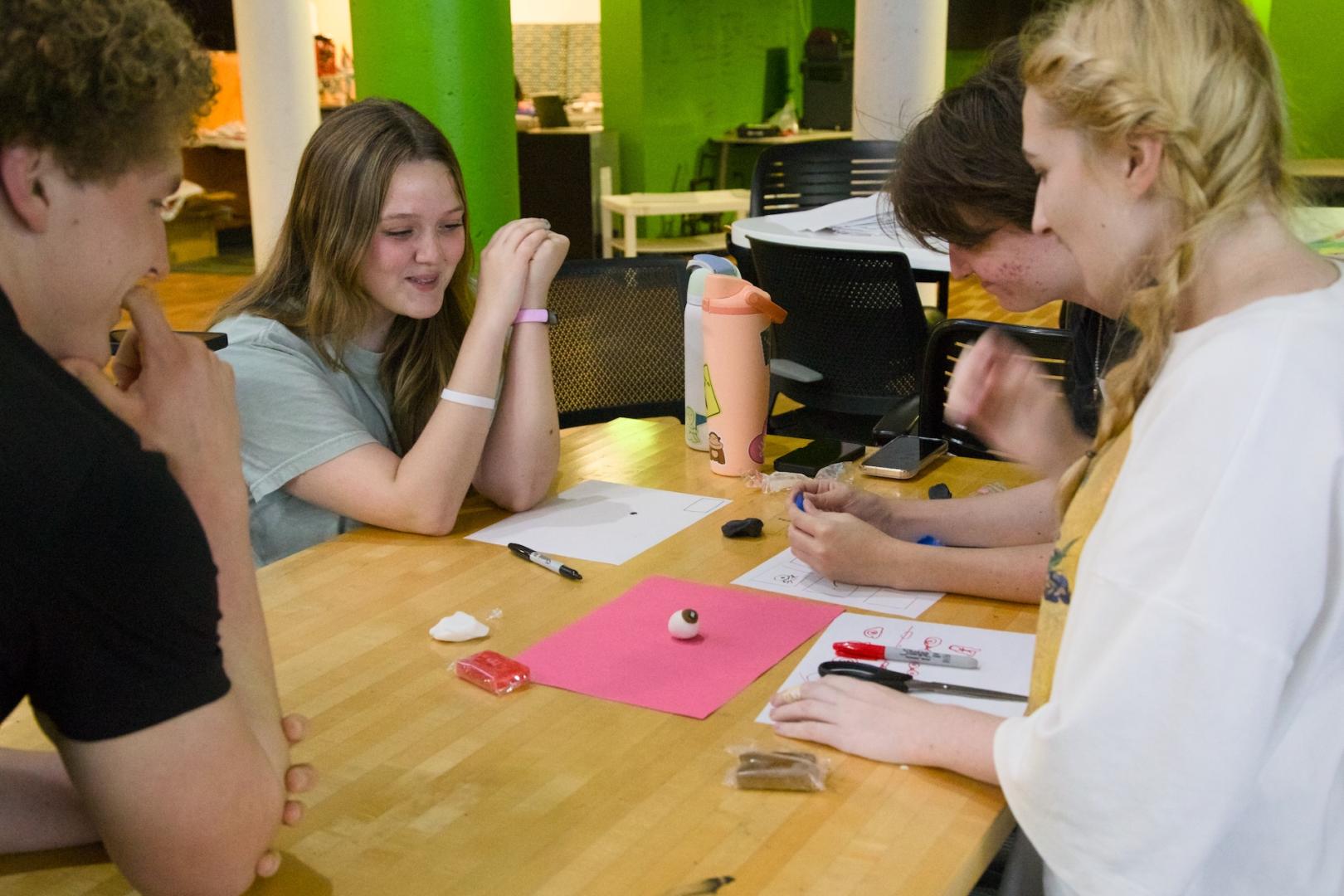 Students trying to film pieces of clay